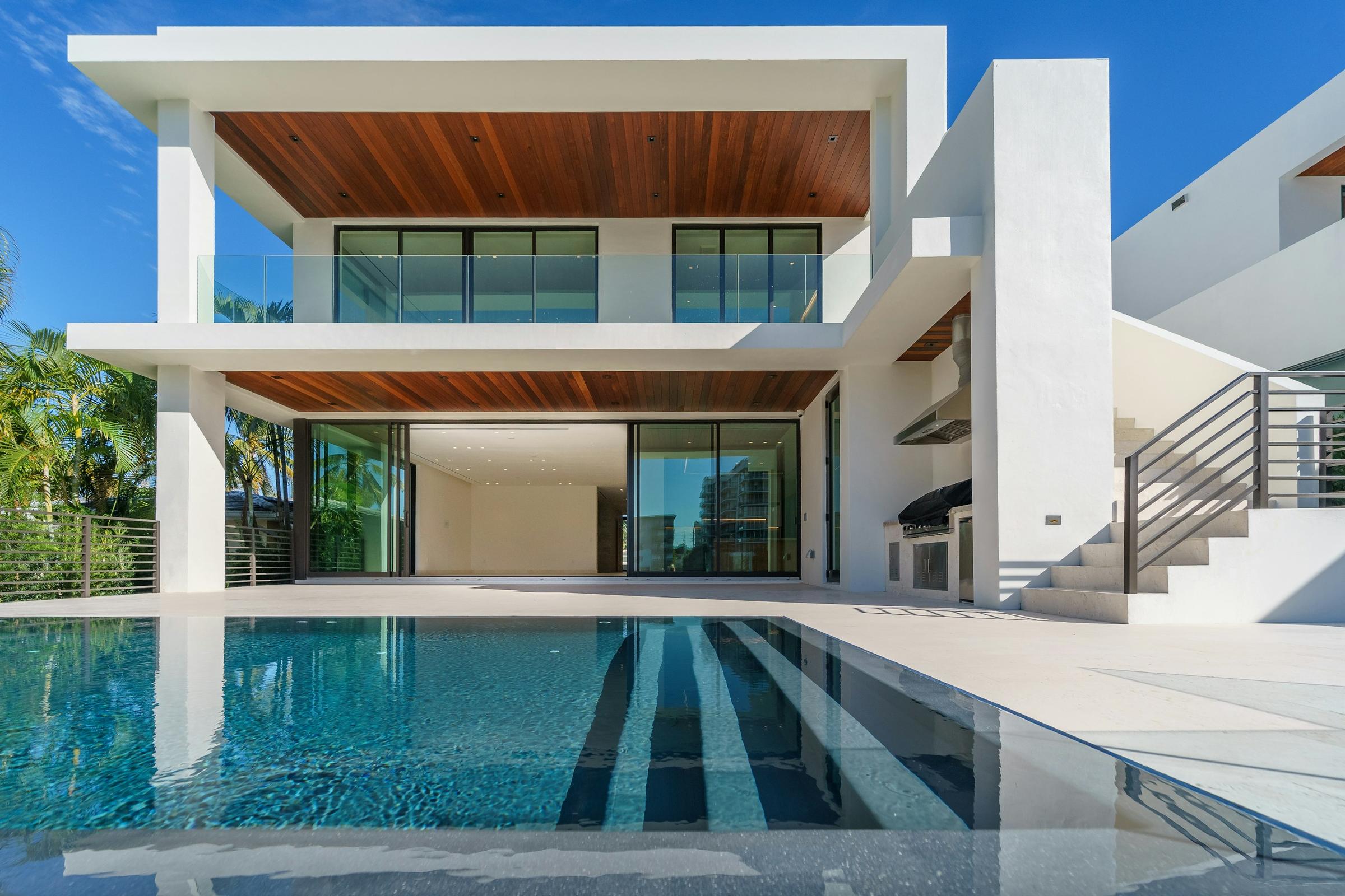 Villa d'architecte contemporaine du Sud, volumes blancs, sous-face en bois et piscine à débordement, image d'ambiance